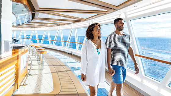 View of a couple holding hands and walking down the deck of a Princess cruise ship.